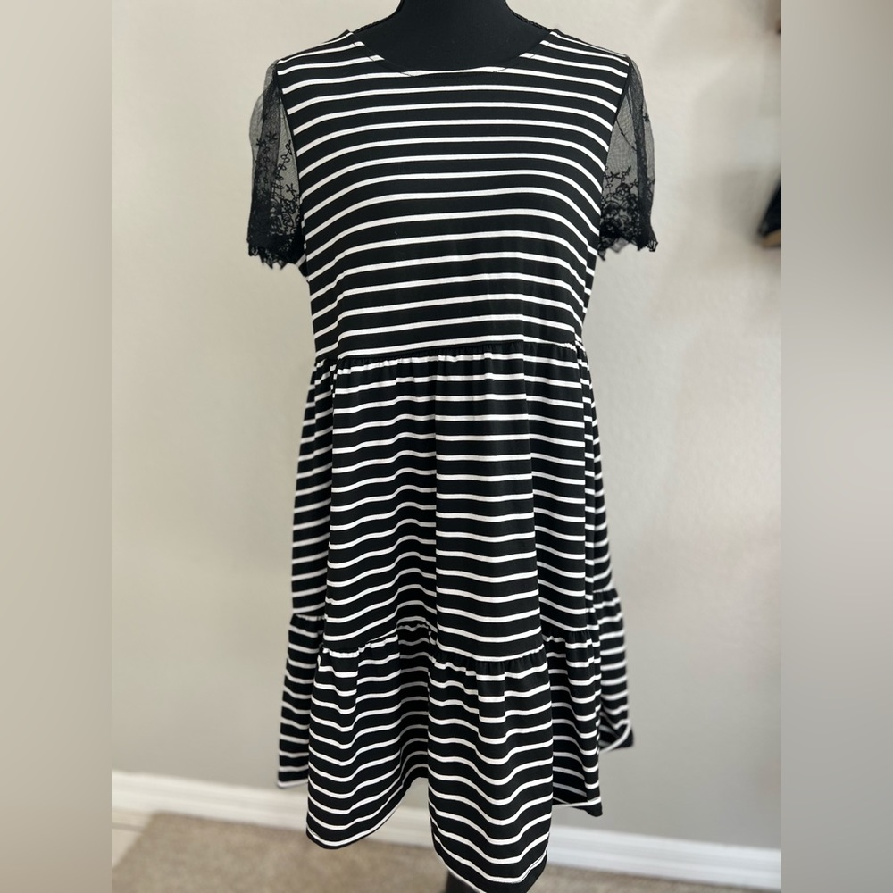 Loose-fitting casual black and white dress with lace sleeves and cutout back